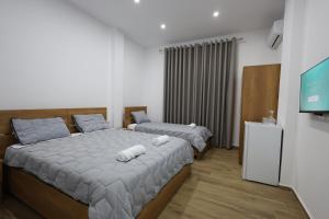 1 Schlafzimmer mit 2 Betten und einem Flachbild-TV in der Unterkunft Guesthouse Aurel in Berat