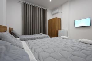 ein Schlafzimmer mit einem großen Bett und einem Flachbild-TV in der Unterkunft Guesthouse Aurel in Berat