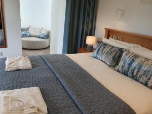 een slaapkamer met een groot bed en een bank bij Woodwick Mill Cottage in Evie