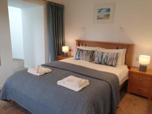 een slaapkamer met een bed met twee handdoeken erop bij Woodwick Mill Cottage in Evie