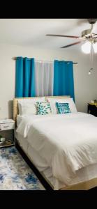 a bedroom with a bed with blue curtains at 1 Bedroom Apartment, in Coconut Drive San Fernando in San Fernando