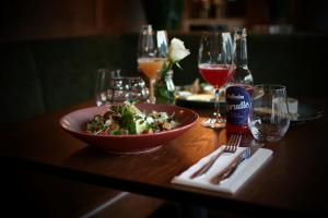een tafel met een kom salade en een glas wijn bij Hotel Aurlandsfjord in Aurland