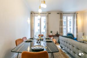 - une salle à manger avec une table et un canapé dans l'établissement MBA - Paris 17 - Luxury Appart, à Paris