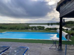 a swimming pool with a table and chairs on a deck at Au cœur du marais breton in Bois-de-Cené