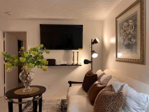 a living room with a white couch and a tv at Victoria Park Regency in Fort Lauderdale