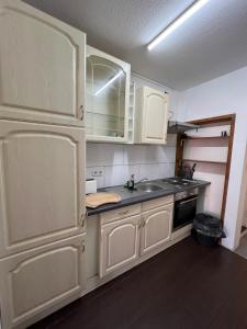 a kitchen with white cabinets and a sink at Zimmervermittlung Hemelingen in Bremen
