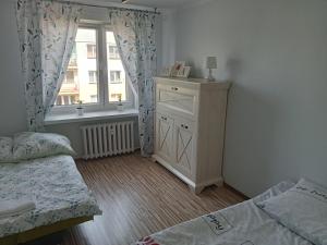 アウグストゥフにあるApartament Konopnickaのベッドルーム1室(ベッド1台、ドレッサー、窓付)