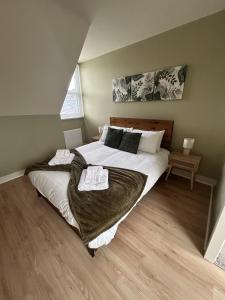 a bedroom with a large bed with towels on it at Kensington Park in Reading