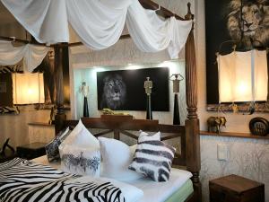 a bedroom with a canopy bed with zebra pillows at Boulevardhotel Sängerstadt - alle Zimmer klimatisiert in Finsterwalde