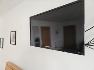 telewizor z płaskim ekranem wiszący na ścianie w obiekcie VitaVer, B&B, STL-OR00012F w mieście Orkady