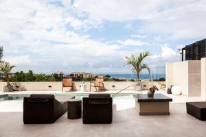 een terras met stoelen en een zwembad bij Orama Luxury Suite with private pool in Chersonissos