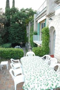 a table and chairs sitting around a white table and chairs at Ferienhaus in Garda mit Garten, Grill und Terrasse in Garda