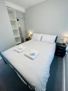 duże białe łóżko z dwoma ręcznikami w obiekcie Modern Airy Chalets short walk to beach, Nr Norfolk Broads & Great Yarmouth w mieście Scratby