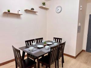 a dining room table with chairs and a clock on the wall at Emerald Avenue Brinchang Muji style in Brinchang