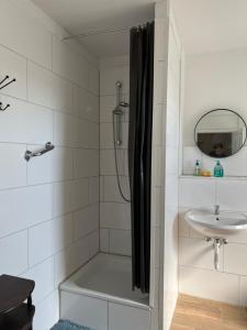 ein Bad mit einer Dusche und einem Waschbecken in der Unterkunft Zimmervermittlung Hemelingen in Bremen