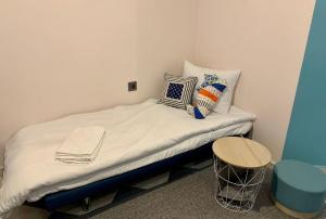 Cette chambre comprend un petit lit avec des oreillers et une table. dans l'établissement Hippocampus, à Varna