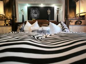 ein schwarzes und weißes Bett mit einem Löwenbild an der Wand in der Unterkunft Boulevardhotel Sängerstadt - alle Zimmer klimatisiert in Finsterwalde
