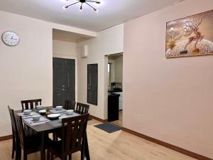 a dining room with a table and chairs and a clock at Emerald Avenue Brinchang Muji style in Brinchang