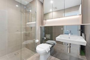 een badkamer met een toilet, een wastafel en een douche bij St Leonards 2B2B Apt with Skyview in Sydney