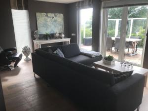 een woonkamer met een bank en een tafel bij Ferienhaus in Makkum Terrasse und Sauna in Makkum