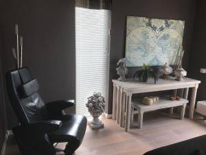ein Wohnzimmer mit einem Stuhl und einem Herzbild in der Unterkunft Ferienhaus in Makkum Terrasse und Sauna in Makkum
