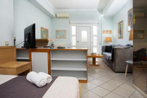 a room with a bed and a tv and a couch at Art of urban hospitality! in Mytilini