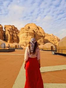 una mujer parada frente a una formación rocosa en Daniela Camp Wadi Rum, en Wadi Rum