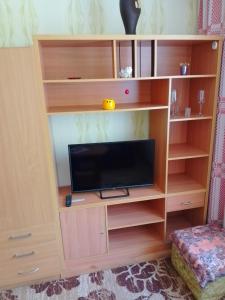 una estantería de madera con TV. en Namas en Klaipėda