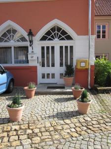 een huis met potplanten ervoor bij Dachgeschosswohnung mit Gartennutzung im Luftkurort Tengen in Tengen