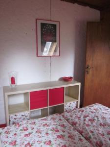 een slaapkamer met een bed en een dressoir met een rode kom bij Dachgeschosswohnung mit Gartennutzung im Luftkurort Tengen in Tengen