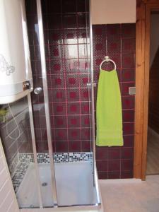 een douche met een groene handdoek aan de muur bij Dachgeschosswohnung mit Gartennutzung im Luftkurort Tengen in Tengen