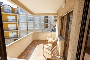 a balcony with two chairs and a building at Vicedo Coastal Paradise in O Vicedo