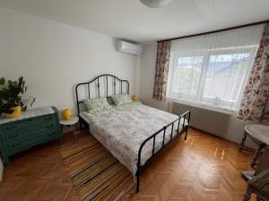a bedroom with a bed and a dresser and two windows at Villa Mint&Lavender in Bled