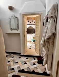 a hallway with a mirror and a doorway into a room at Riad Tizwa Marrakech in Marrakesh
