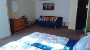 ein Wohnzimmer mit einem blauen Sofa und einem Tisch in der Unterkunft Ferienwohnung für 6 Personen ca 80 m in Gößweinstein-Hardt, Bayern Franken in Gößweinstein