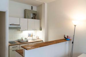 een keuken met witte kasten en een houten aanrecht bij Charming Studio With View Near The Sacré Coeur! in Parijs