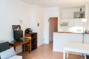 een woonkamer met een bank en een tv op een tafel bij Charming Studio With View Near The Sacré Coeur! in Parijs