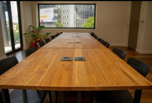 duży drewniany stół konferencyjny w pokoju z krzesłami w obiekcie Blackbrick Sandton two no-loadshedding w mieście Johannesburg