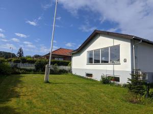 a white house with a yard in front of it at Sommerhus ved strand og lystbådhavn Søby - Ærø in Søby