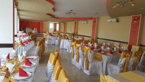 - une salle de banquet avec des tables blanches, des chaises et des serviettes rouges dans l'établissement Pensiune Restaurant Avangarde, à Piteşti