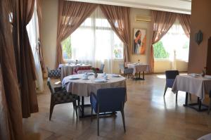 un comedor con mesas, sillas y ventanas en Residence Intouriste, en Agadir