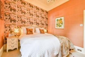 1 dormitorio con 1 cama y pared cubierta de papel pintado en Gemütliche Wohnung mit einem Schlafzimmer, mit Blick auf den Garten des Anwesens en Torquay