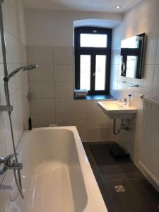 uma casa de banho com uma banheira e um lavatório em Schöne Ferienwohnung in Sinsheim mit Großer Terrasse em Sinsheim