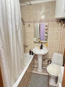 a bathroom with a tub and a sink and a toilet at 1-комнатные апартаменты на улице Естая, дом 89 напротив ТД Артур in Pavlodar