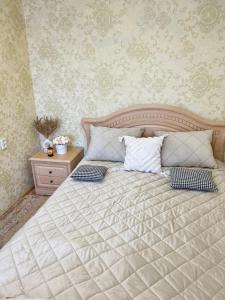 a bedroom with a bed with two pillows on it at 1-комнатные апартаменты на улице Естая, дом 89 напротив ТД Артур in Pavlodar