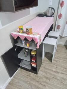 拉熱斯的住宿－POUSADA ALTERNATIVA MANU LAGES Quarto wc comp，一张小桌子,放在一个配有粉红色桌子的房间