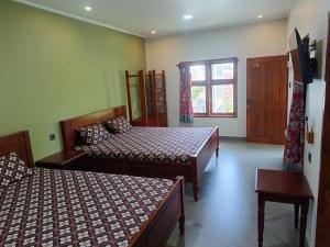 a bedroom with two beds and a window at Mango Guesthouse in Pangandaran