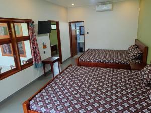 - une chambre avec 2 lits et une fenêtre dans l'établissement Mango Guesthouse, à Pangandaran
