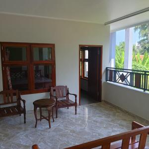 a room with chairs and a table and a balcony at Mango Guesthouse in Pangandaran