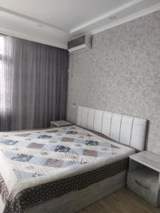 sypialnia z łóżkiem z kołdrą w obiekcie Apartment Vesta w Kobuleti